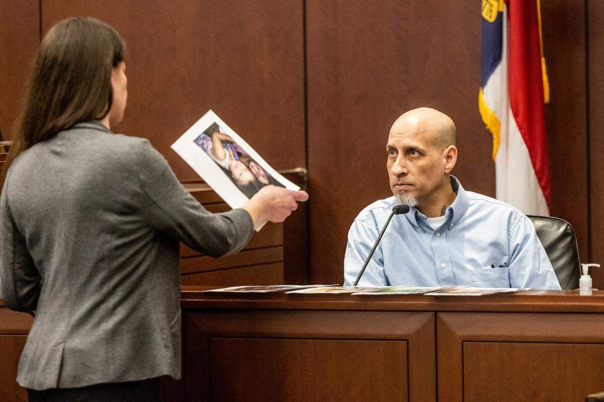 Prosecuter Kathryn Pomeroy confronts Brian Sluss with photos of his girlfriend and their children at the conclusion of his testimony Wednesday, April 27, 2022 in Wake county District Court. Sluss, 46, is charged with the murder of Monica Moynan, who was 23 when she was last seen in Holly Springs in April 2019. Moynan, who shared two children with Sluss, was reported missing in mid-July of 2019, and her body has never been found.