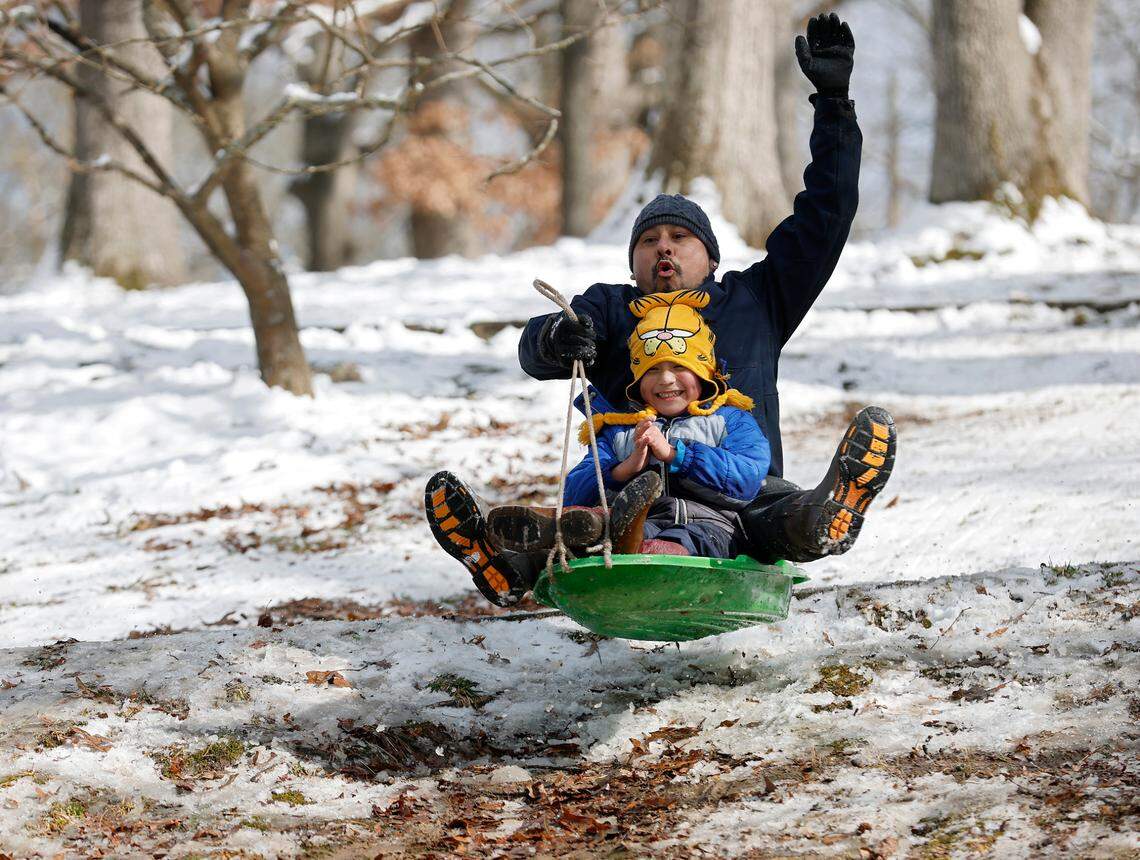 Javier Tamez and his son, Mateo, 5, catch some air while sledding at Duke Park on Thursday, Feb. 20, 2025, in Durham, N.C.