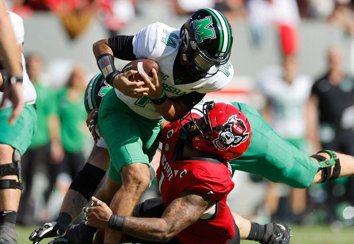N.C. State defensive tackle Davin Vann (1) sacks Marshall quarterback Cam Fancher (14) during the first half of N.C. State’s game against Marshall at Carter-Finley Stadium in Raleigh, N.C., Saturday, Oct. 7, 2023.