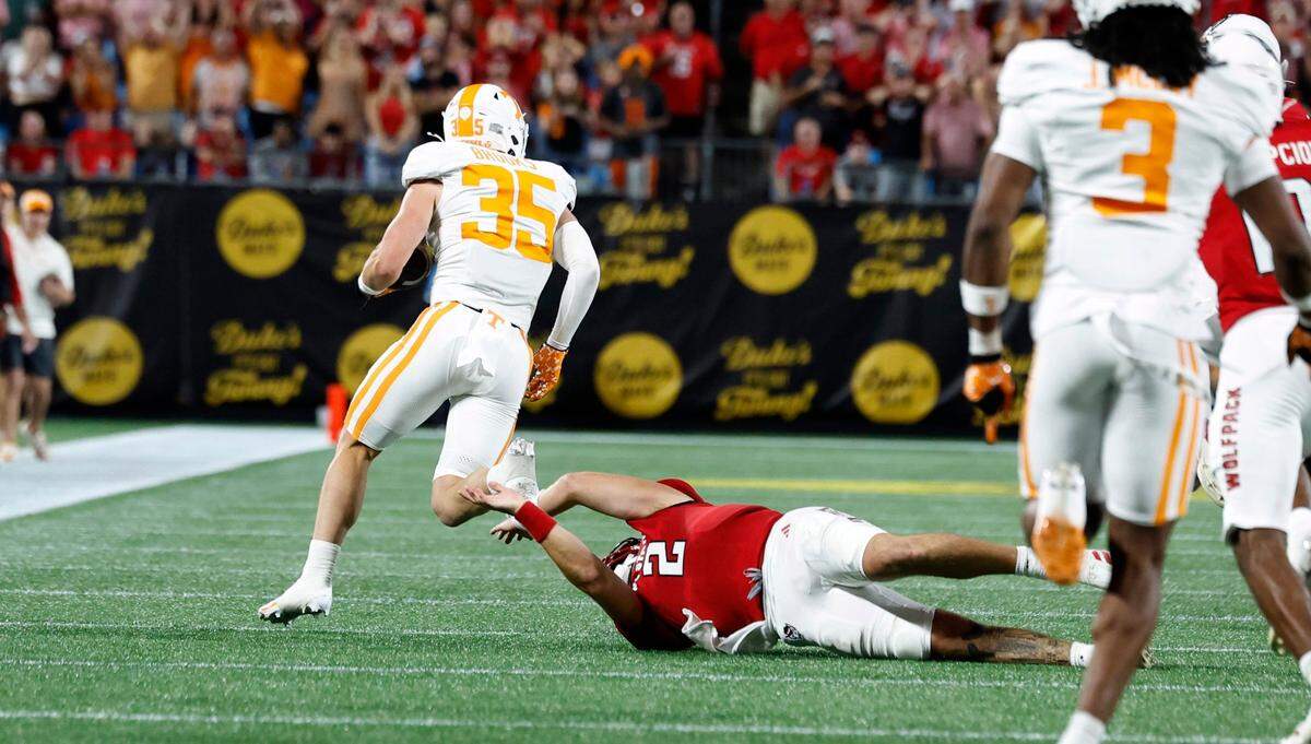 Tennessee’s Will Brooks (35) beats N.C. State quarterback Grayson McCall (2) as he returns an interception for a touchdown during the first half of N.C. State’s game against Tennessee in the Duke’s Mayo Classic at Bank of America Stadium in Charlotte, N.C., Saturday, Sept. 7, 2024.