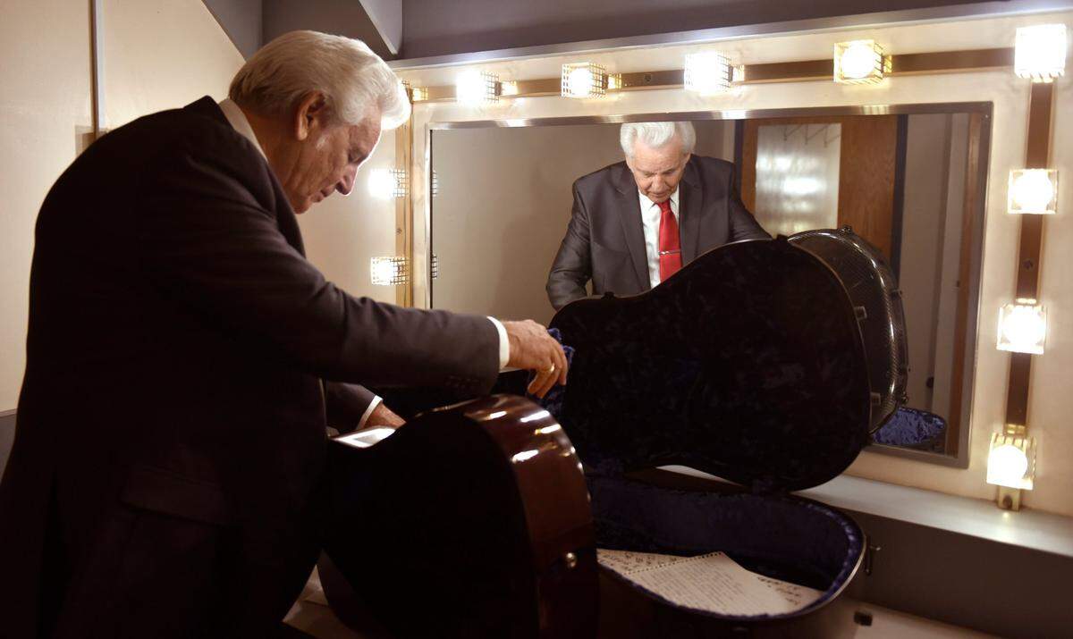Del McCoury unpacks his instruments in his band’s dressing room before performing at the IBMA Awards in Raleigh, N.C..