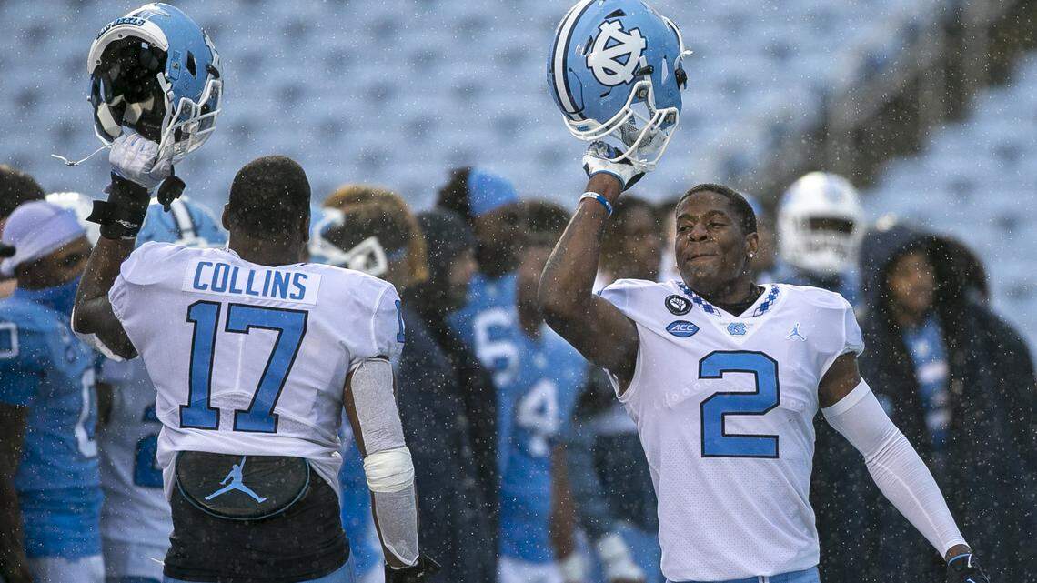 North Carolina’s Don Chapman (20) and teammate Chris Collins (17) celebrate in the rain as the band plays the Alma Mater at the conclusion of the Tar Heels’ Spring football game on Saturday, April 24, 2021 in Chapel Hill, N.C.