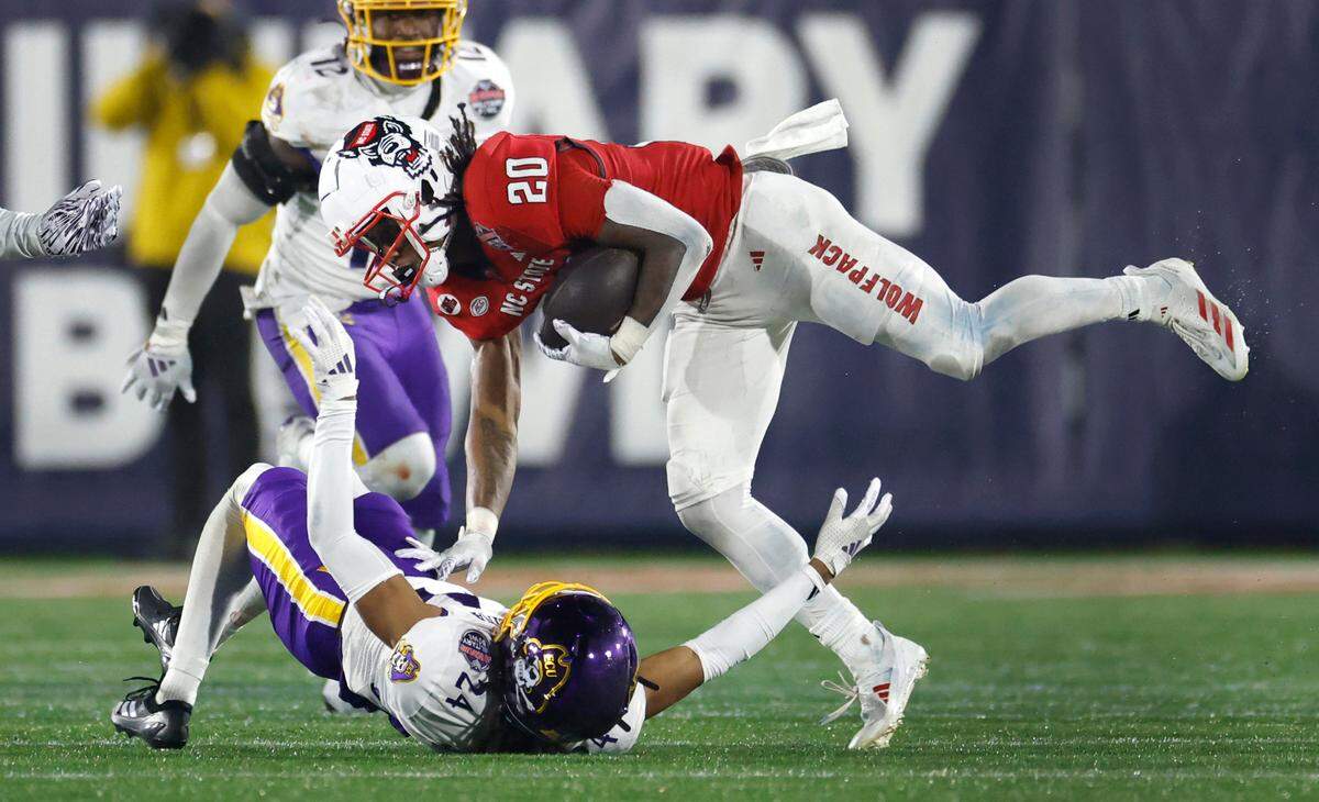N.C. State running back Hollywood Smothers (20) keeps his balance over East Carolina defensive back TyMir Brown (24) during the second half of ECU’s 26-21 victory over N.C. State in the Military Bowl at Navy-Marine Corps Memorial Stadium in Annapolis, Md., Saturday, Dec. 28, 2024.