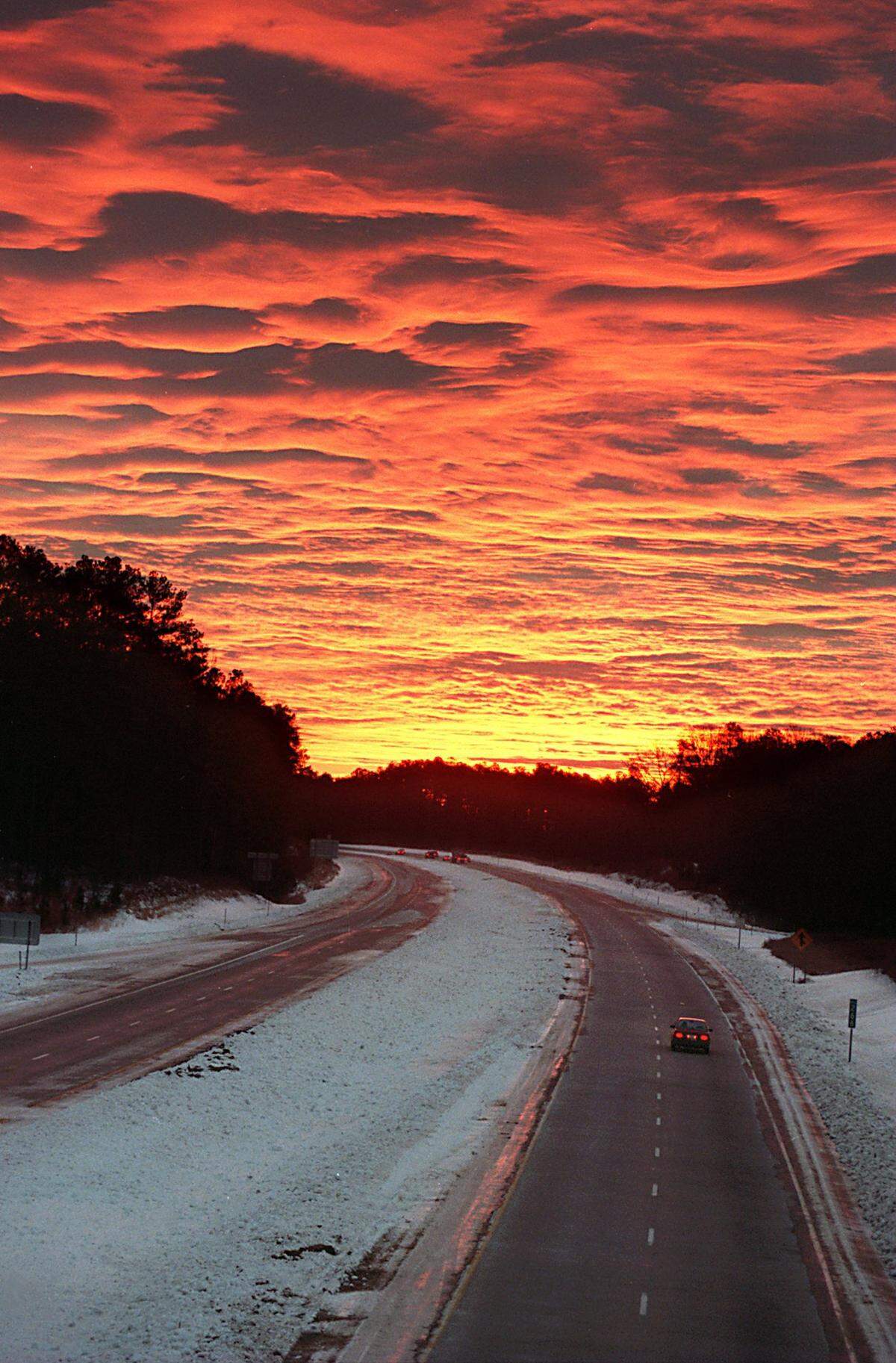 A dramatic sunrise rolling a 1996 snow storm seen from the NC 86 bridge over I-40 in Orange County.