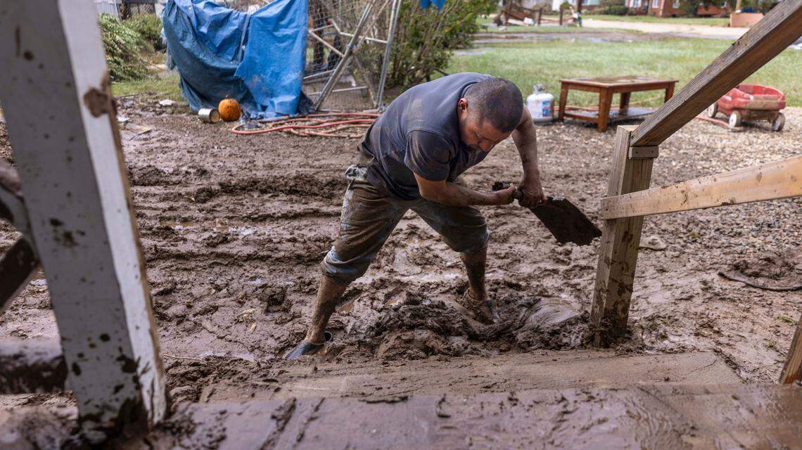 Tomas Quiroz shovels mud from his porch steps in Clyde on Saturday, Sept. 28, 2024 after massive flooding damaged dozens of homes and businesses. The remnants of Hurricane Helene caused widespread flooding, downed trees, and power outages in western North Carolina.