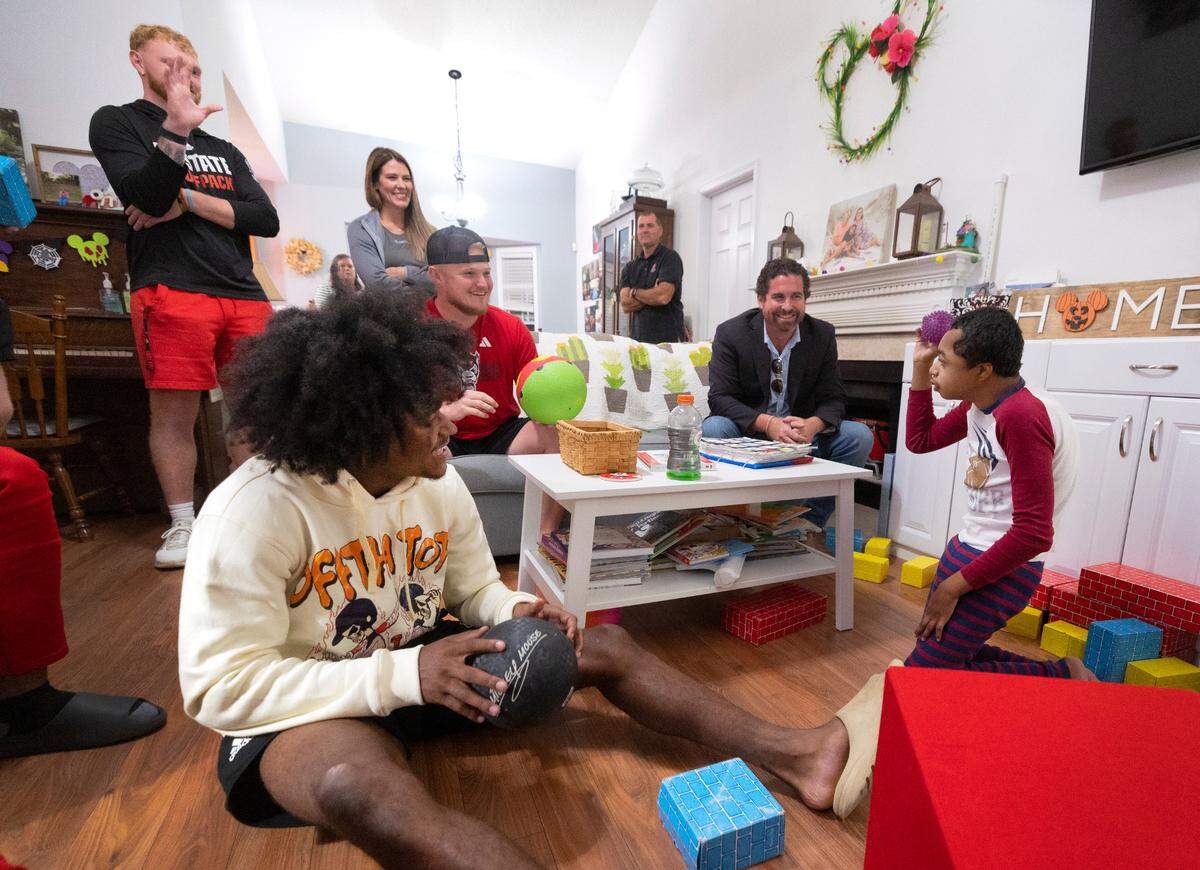 Grayson Ketchie plays ball with N.C. State football players including KC Concepcion, left, at Grayson’s home in Garner Wednesday, Oct. 18, 2023. Ketchie, 12, has been suffering from severe neurological issues since he was a baby. He has been a Wolfpack fan since he was three and the players made a surprise visit to his home that evening.