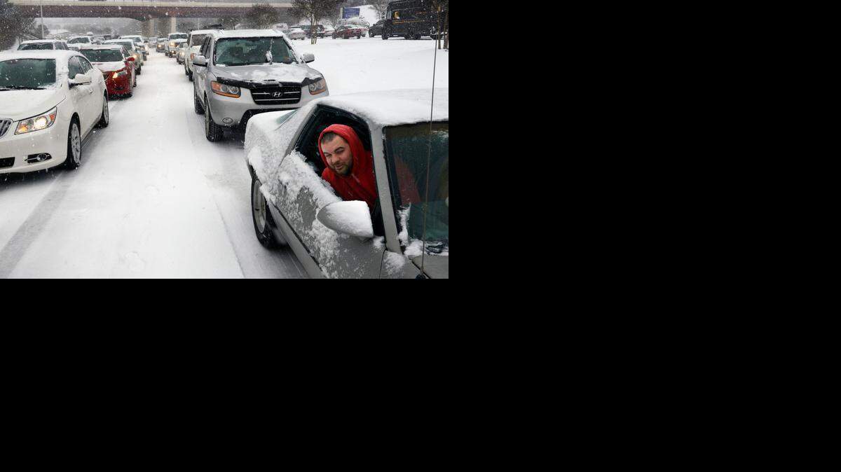 Kevin Miller looks out of the passenger window of his friend's car as they sit in stuck traffic Wednesday afternoon Feb. 12, 2014 after snow and ice caused massive traffic jams in Raleigh, NC.
