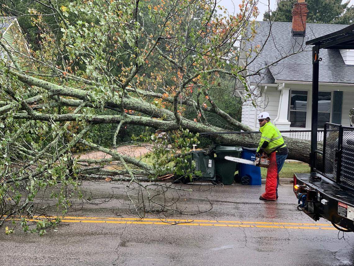 A City of Raleigh worker starts his chainsaw to begin removing a fallen tree from power lines on Dixie Trail, Friday, Sept. 30, 2022 as winds from Hurricane Ian started to move through the area.