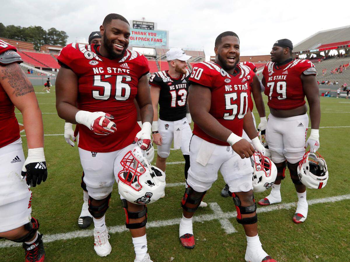 N.C. State’s Bryson Speas (56) laughs with Grant Gibson (50) as they walk off the field after the Wolfpack’s spring game at Carter-Finley Stadium in Raleigh, N.C., Saturday, April 10, 2021.