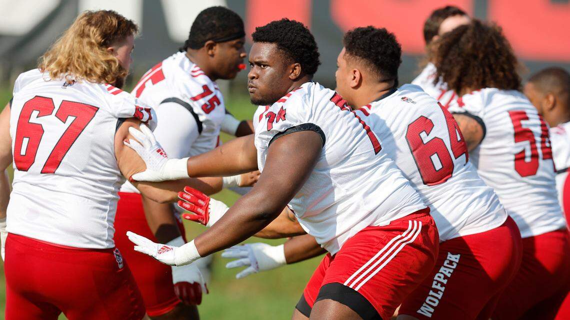 N.C. State’s Anthony Belton (74) blocks while drilling during the Wolfpack’s first practice of fall camp in Raleigh, N.C., Wednesday, August 3, 2022. Belton is blocking Brendan Lawson (67).