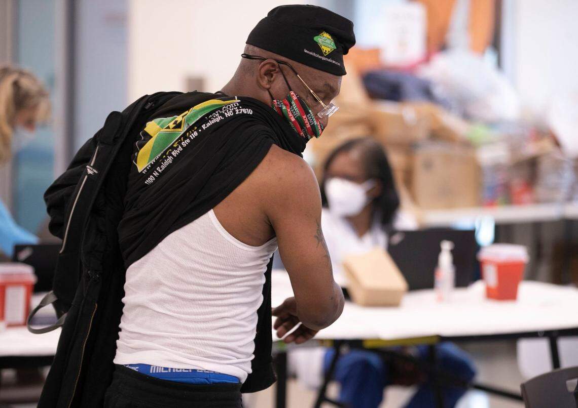 Anthony Pierce removes his shirt to receive his Johnson & Johnson COVID-19 vaccine during a clinic at Oak City Cares on Thursday, March 25, 2021 in Raleigh, NC. Wake County Public Health partnered with Oak City Cares to vaccinate people that use congregate housing like the South Wilmington Street Center next door.