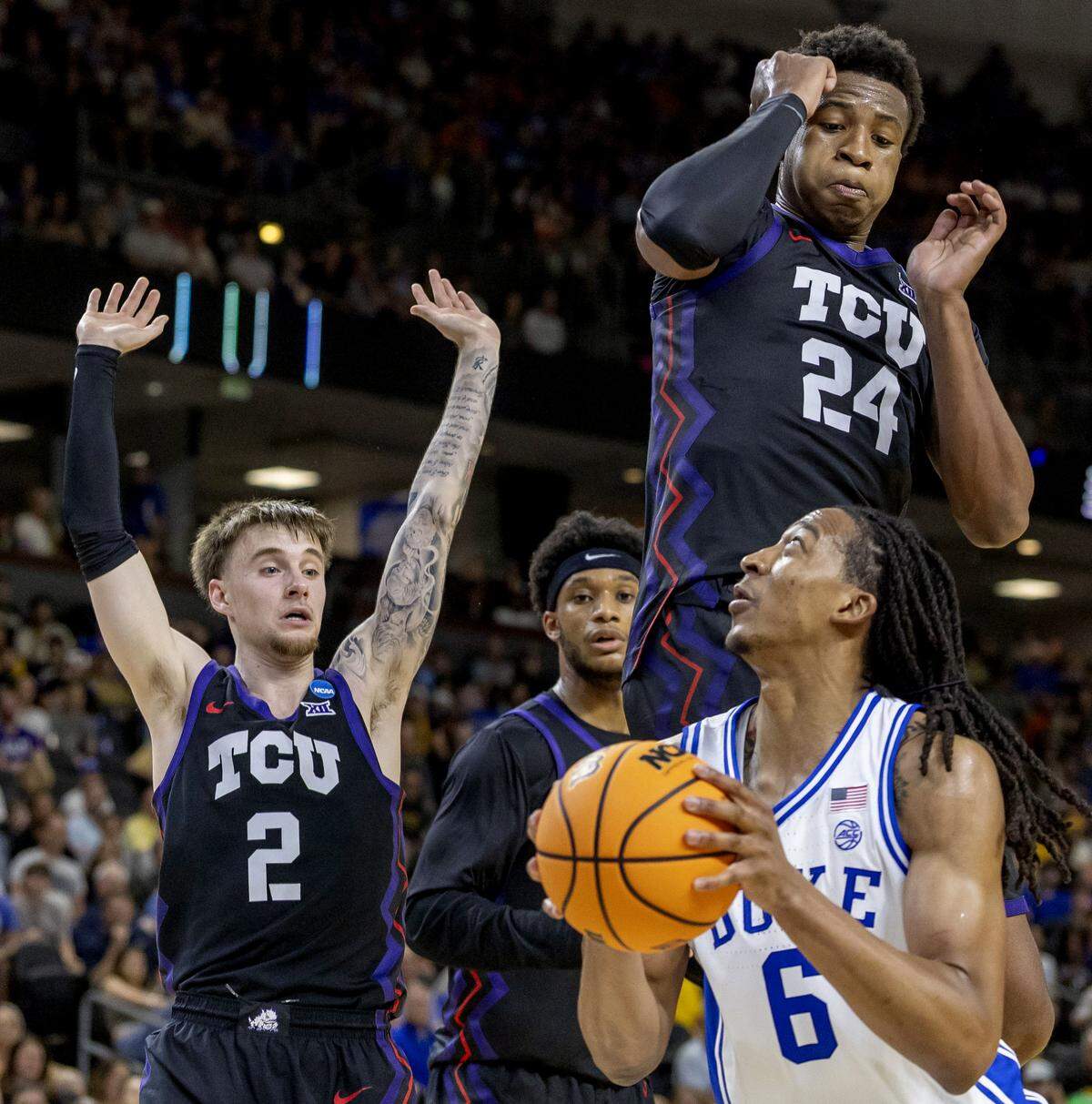 TCU forward Xavier Edmonds (24) and guard Brock Harding (2) defend Duke forward Maliq Brown (6) in the first half on Saturday, March 21, 2026, during the second round of the NCAA Tournament at Bon Secours Arena in Greenville, S.C.