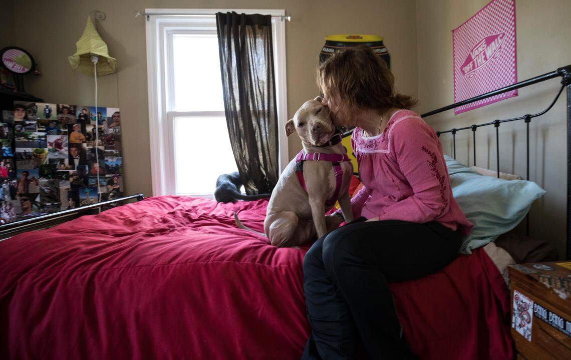 Susan Plattner kisses her dog, Maya, in her son Caleb Mehlman's room on March 16. Caleb, a graduate of Leesville Road High School, died from an overdose involving Xanax and methadone on Dec. 19, 2017, his 19th birthday.