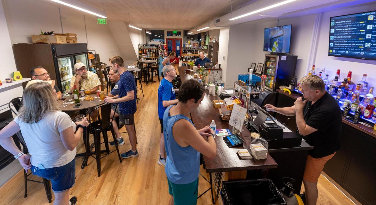 Drew Temple, right, serves customers at The Green Monkey bar on Tuesday, September 12, 2023 in Raleigh, N.C.