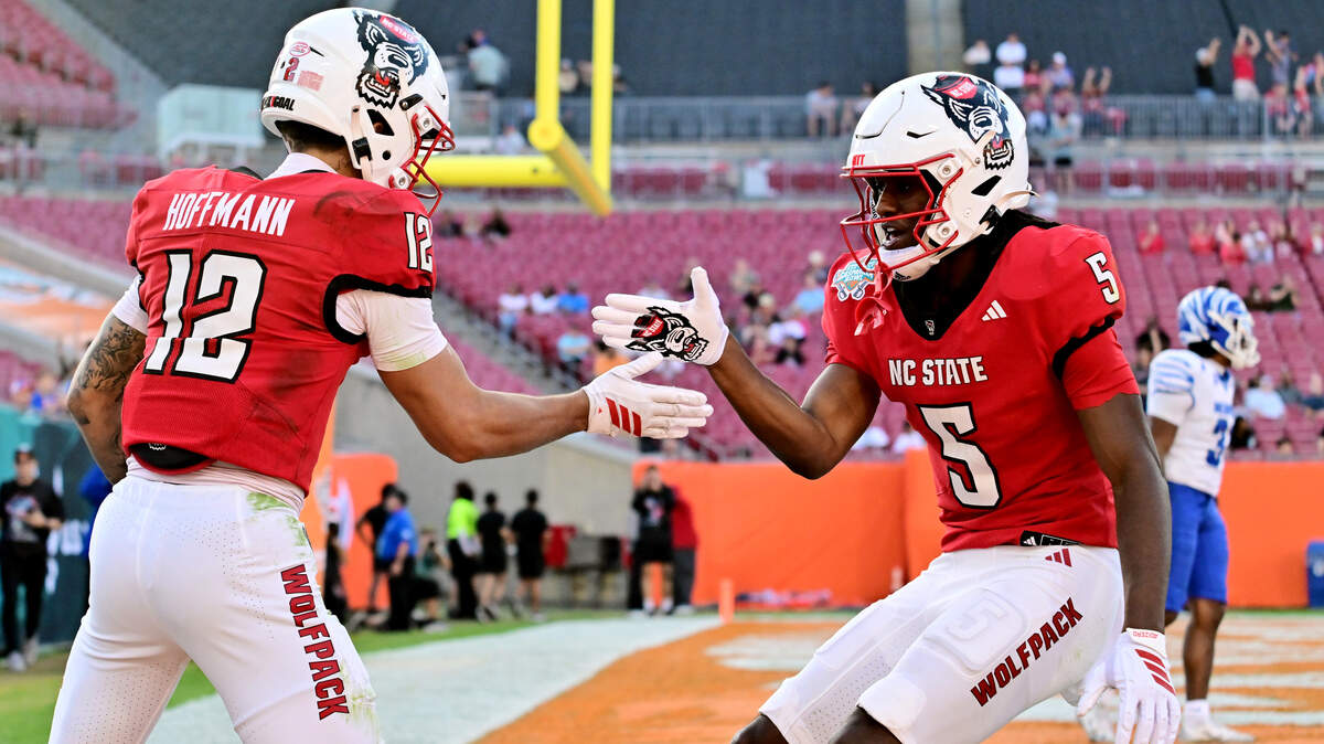Teddy Hoffmann (12) celebrates with Noah Rogers (5) of the NC State Wolfpack after scoring a touchdown in the first half against the Memphis Tigers during the 2025 Union Home Mortgage Gasparilla Bowl at Raymond James Stadium on December 19, 2025 in Tampa, Florida.  