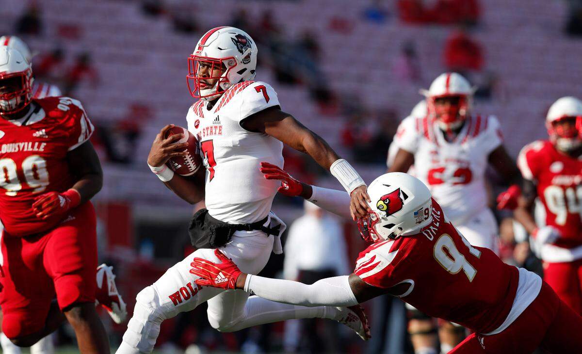N.C. State quarterback Matthew McKay (7) tries to run pass Louisville linebacker Nick Okeke (97) during the second half of N.C. State’s 52-10 victory over Louisville at Cardinal Stadium in Louisville, Ky. Saturday, Nov. 17, 2018.