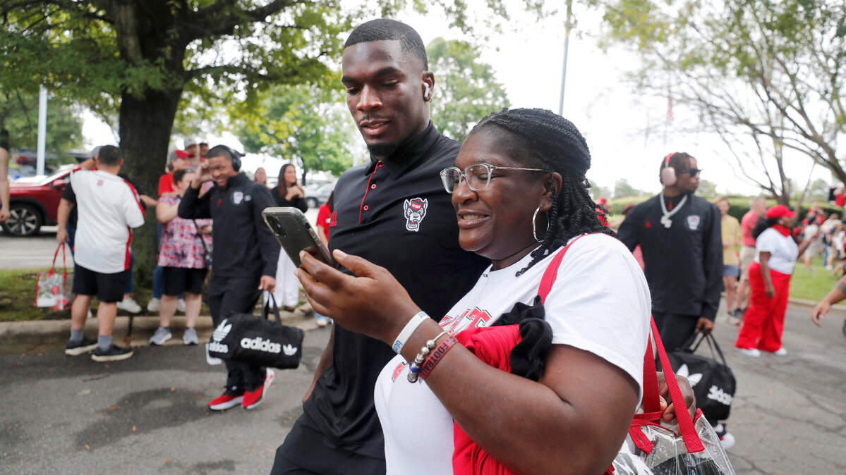 N.C. State’s Jordan Waters greets his mom Tonya Fleming during the Walk of Champions before the Wolfpack’s game against Louisiana Tech at Carter-Finley Stadium on Sept. 14, 2024.