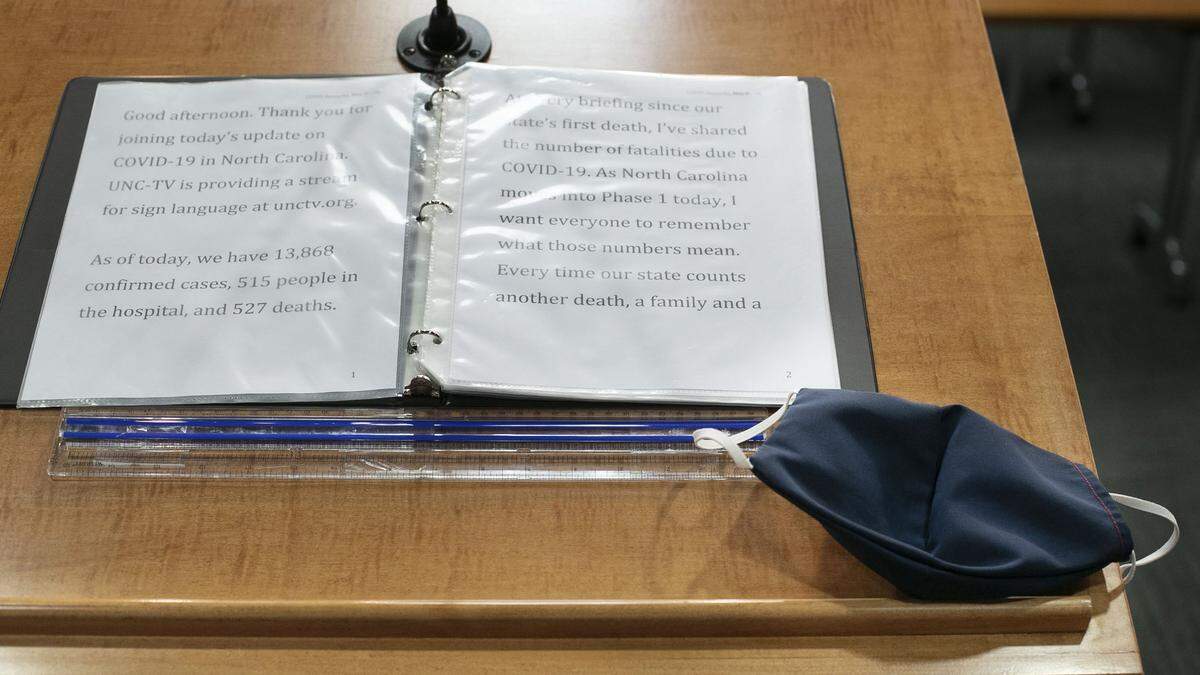 The protective mask that North Carolina Governor Roy Cooper wears is placed on the lectern next to his notes for his press briefing on the COVID-19 virus on Friday, May 8, 2020 at the Emergency Operation Center in Raleigh, N.C.