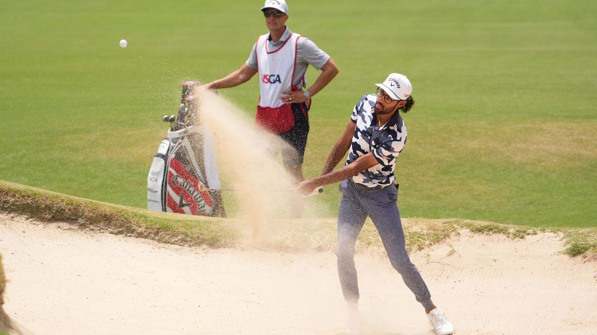 Akshay Bhatia hits from the bunker on the first green during the final round of the U.S. Open golf tournament.