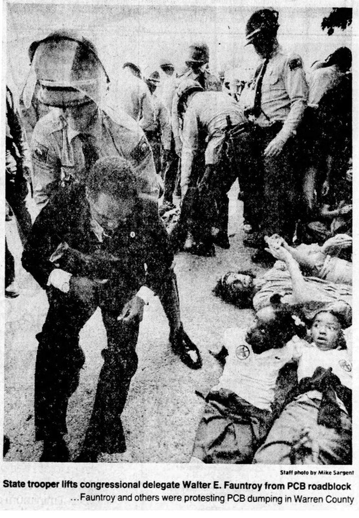 A file photo from The News & Observer shows law enforcement moving people out of the way of trucks carrying PCB-laden soil to a Warren County field. The protest is widely seen as the start of the environmental justice movement.
