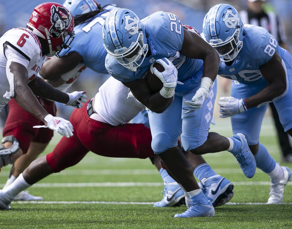 North Carolina’s Javonte Williams (25) rushes for a first down in the second quarter against N.C. State at Kenan Stadium on Saturday, October 24, 2020 in Chapel Hill, N.C.