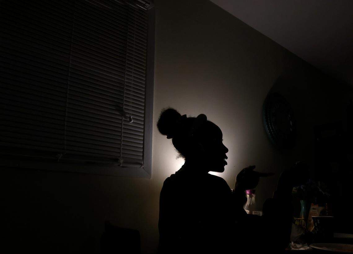 Ahava Edgerton, 16, is silhouetted by a table lamp as she eats dessert while sitting with her sisters after dinner at their Durham, N.C. home on Wednesday, Oct. 26, 2022.