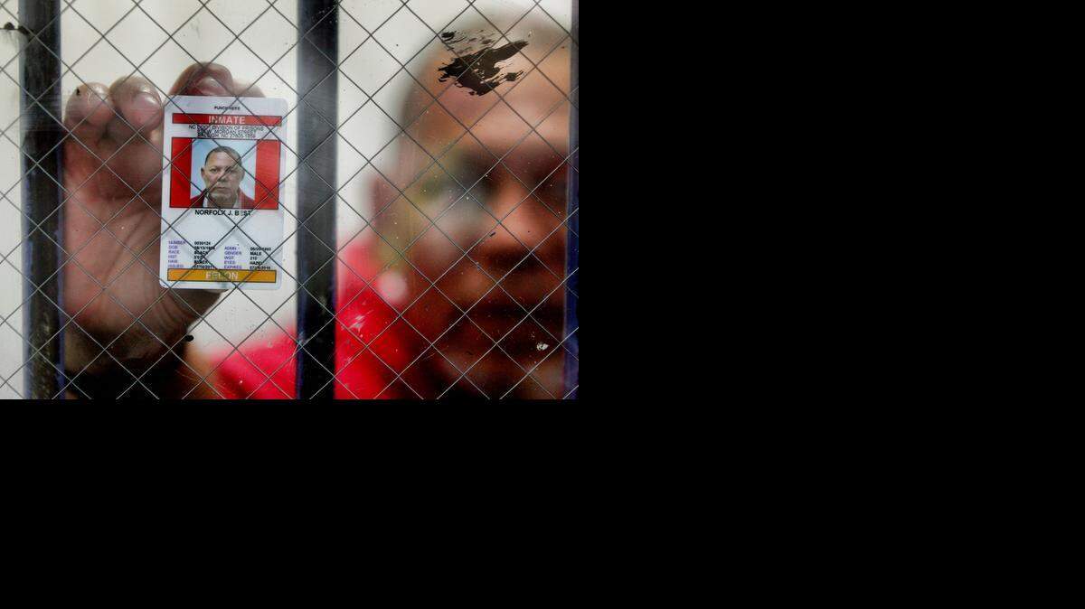Norfolk “Fuzzy” Best has continually proclaimed his innocence in the 1991 killings of a couple in Whiteville. He was convicted of murder in 1993 and sentenced to death. Here, he presses his Central Prison ID card against the thick glass of an interview room. 
