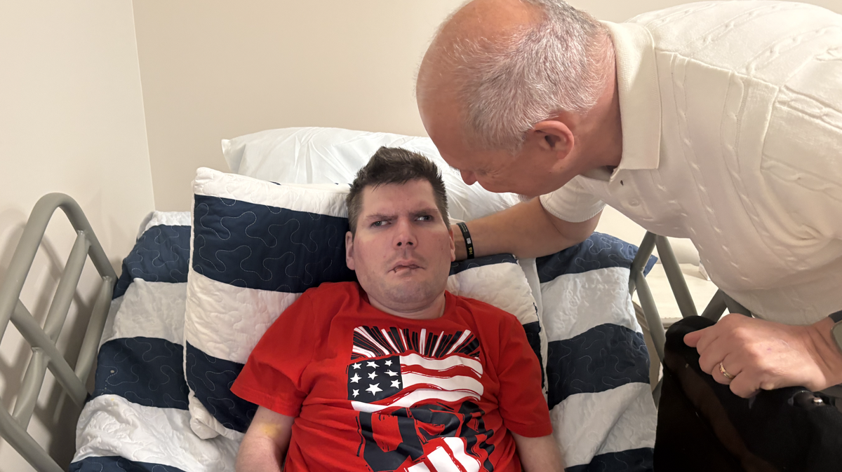 Doug Watson (right) gets his son, Tommy, settled in his new room at TLC’s new intermediate care facility in Raleigh.