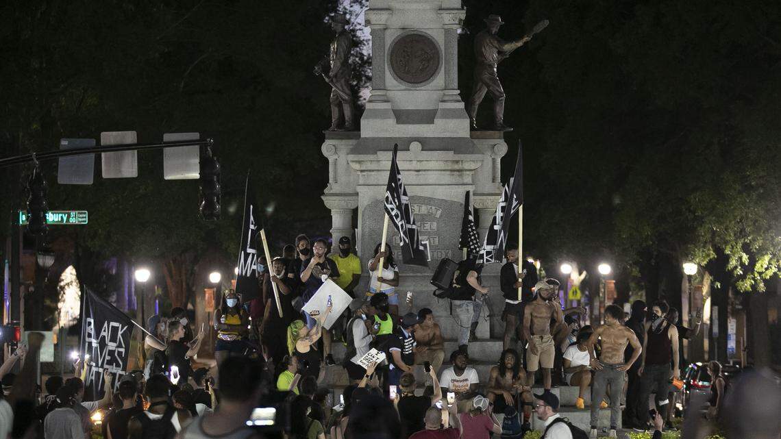 Demonstrators assemble on the Confederate monument on the State Capital grounds after marching through downtown on Saturday, June 6, 2020 in Raleigh, N.C.
