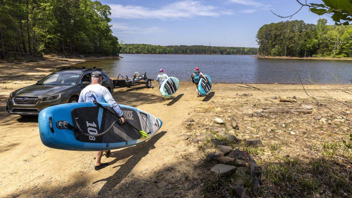 Paddleboarders launch from the Beaver Dam Primitive Access Area on Thursday, April 16, 2026, as central North Carolina faces drought conditions and water restrictions. The lake’s water level was about 249 feet on April 15, according to the U.S. Geological Survey, following little recent rainfall.