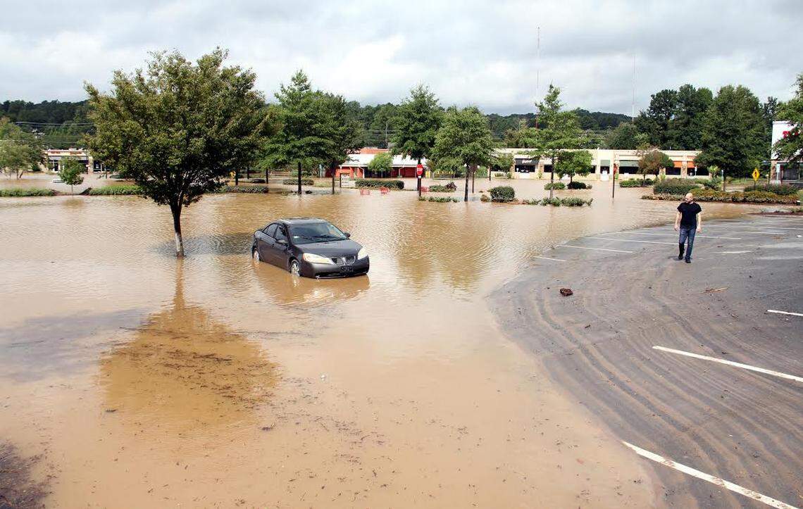 Steve Hammer, 40, returns to his Pontiac G6 at Eastgate Crossing in Chapel Hill on Monday. He had left the car at the shopping center when the battery shorted Sunday and had not thought about the possibility of flooding. The water peaked just below the door handles.