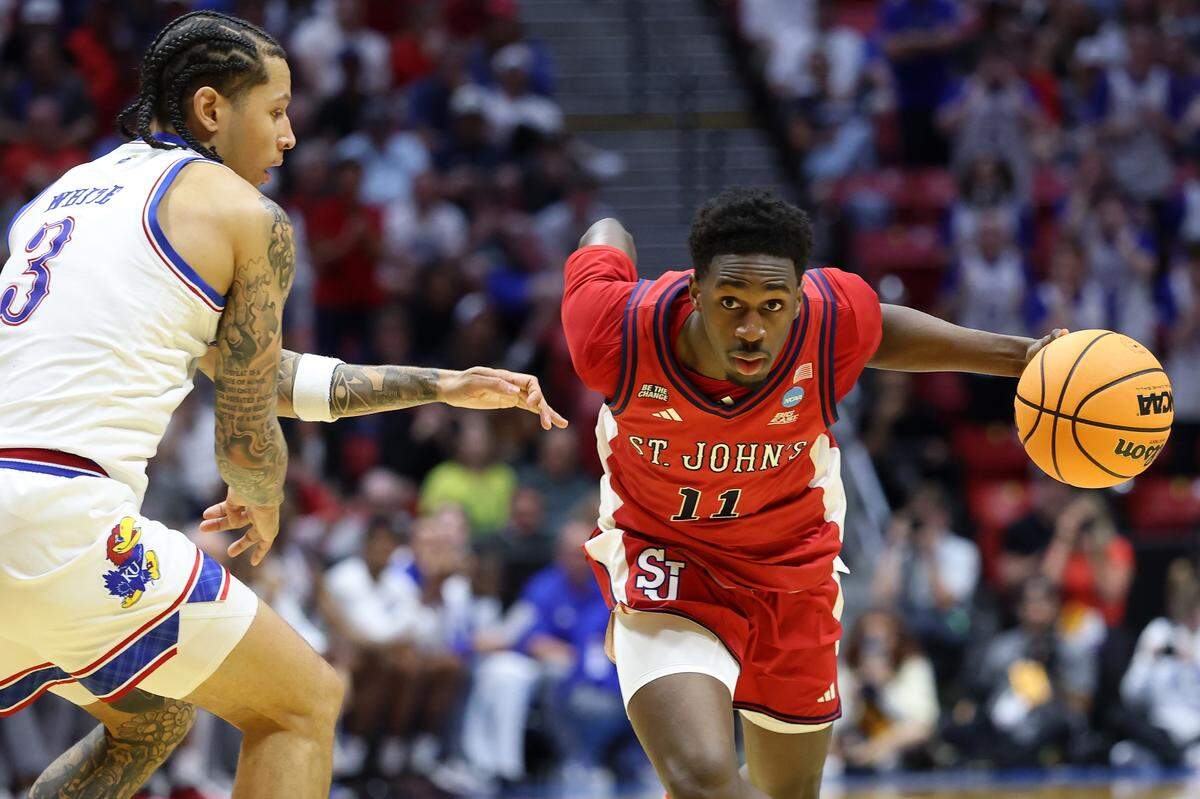 Ian Jackson (11) of the St. John's Red Storm drives to the basket against Tre White of Kansas during the second half of the teams’ 2026 NCAA Men's Basketball Tournament game at Viejas Arena at San Diego State University on March 22, 2026 in San Diego, California.