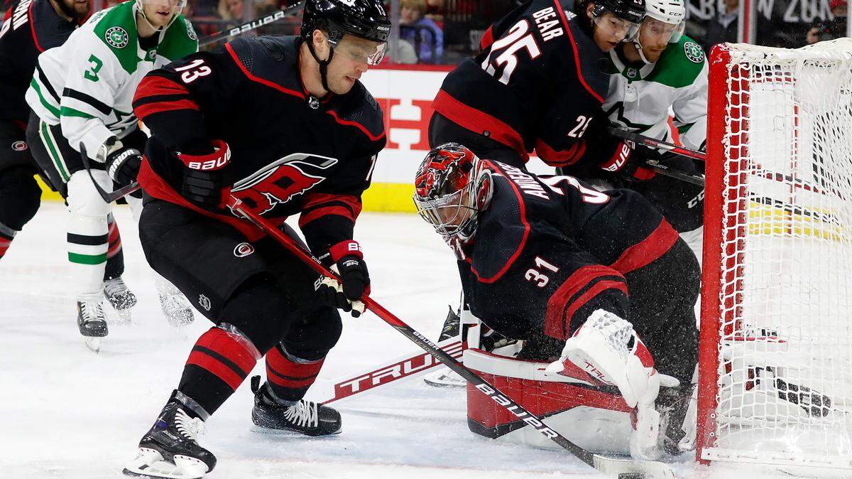 Carolina Hurricanes’ Max Domi (13) helps goaltender Frederik Andersen (31) clear the puck against the Dallas Stars during the first period of an NHL hockey game in Raleigh, N.C., Thursday, March 24, 2022. (AP Photo/Karl B DeBlaker)