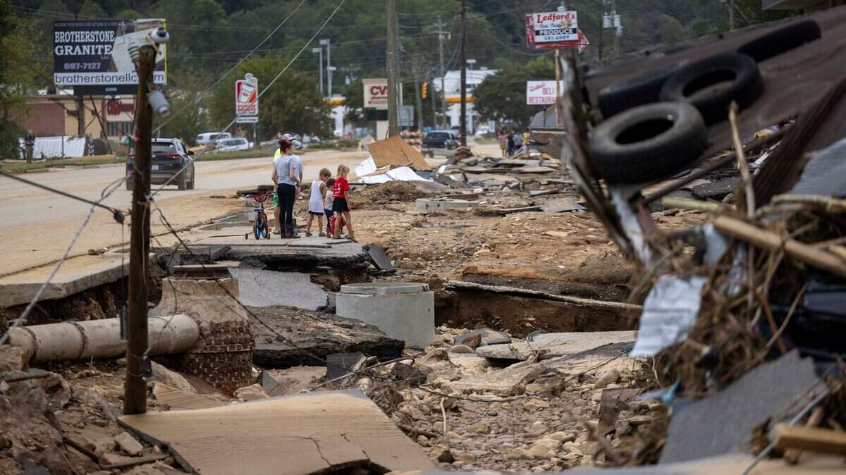 Swannanoa residents walk through devastating flood damage from the Swannanoa River on Sunday, Sept. 29, 2024. The remnants of Hurricane Helene caused widespread flooding, downed trees, and power outages in western North Carolina.