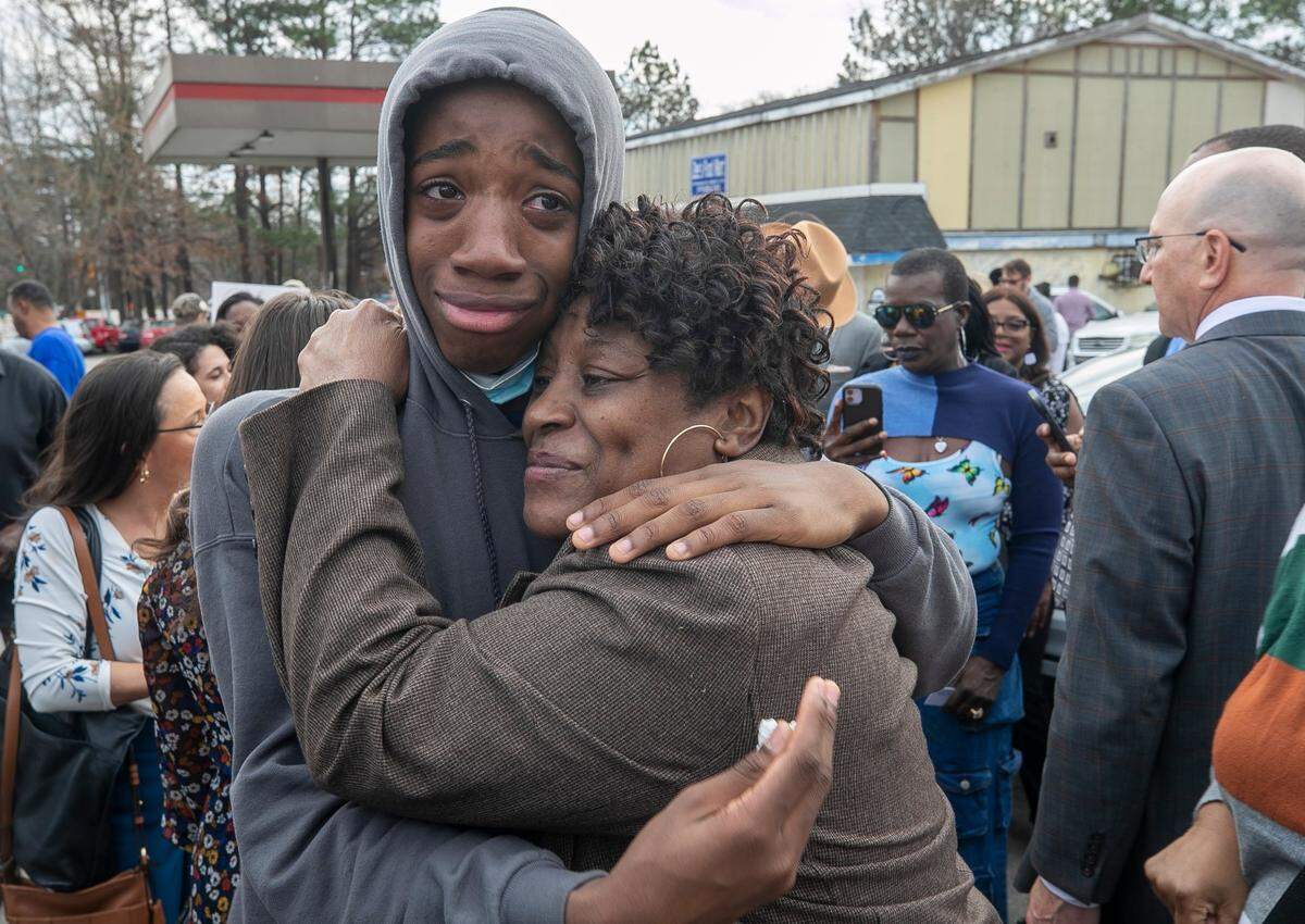 Sonya Williams, the mother of Darryl Williams, embraces son Zayvien Williams in 2023 after laying a bouquet of flowers at a memorial on Rocky Quarry Road, near were Darryl Williams died.
