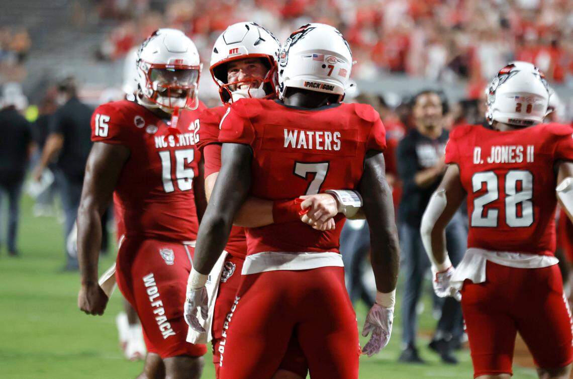 N.C. State quarterback Grayson McCall (2) hugs running back Jordan Waters (7) after Waters scored on a 50-yard touchdown run during the second half of N.C. State’s 38-21 victory over Western Carolina at Carter-Finley Stadium in Raleigh, N.C., Thursday, August 29, 2024.