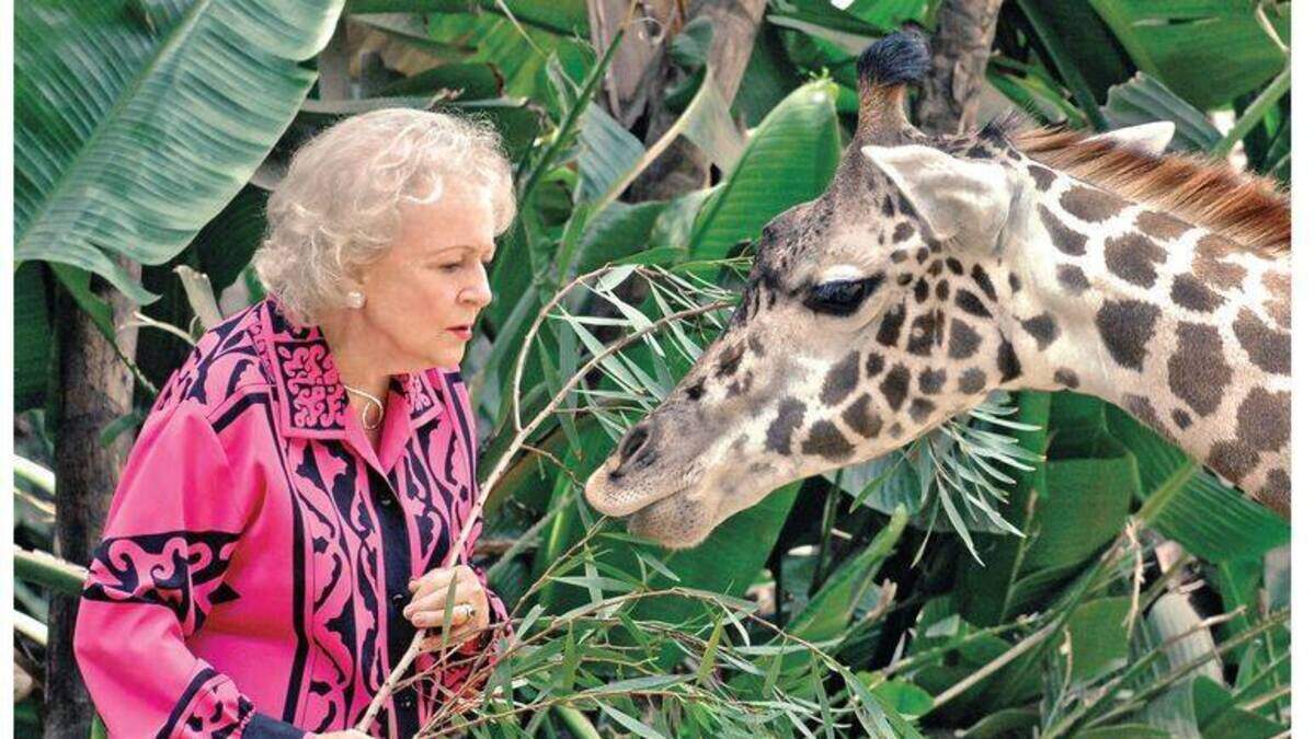 TV legend Betty White with a giraffe. White, a devoted animal advocate, is the subject of a PBS documentary debuting on Aug. 21.