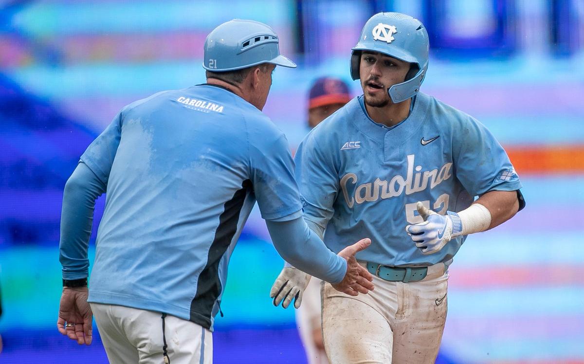 North Carolina coach Scott Forbes congratulates Tomas Frick (52) as he rounds third base, after connecting for a home run in the ninth inning against Clemson during the semi-finals of the 2023 ACC Baseball Championship on Saturday, May 27, 2023 at Durham Bulls Athletic Park in Durham, N.C. The Tar Heels fell 10-4 to Clemson.