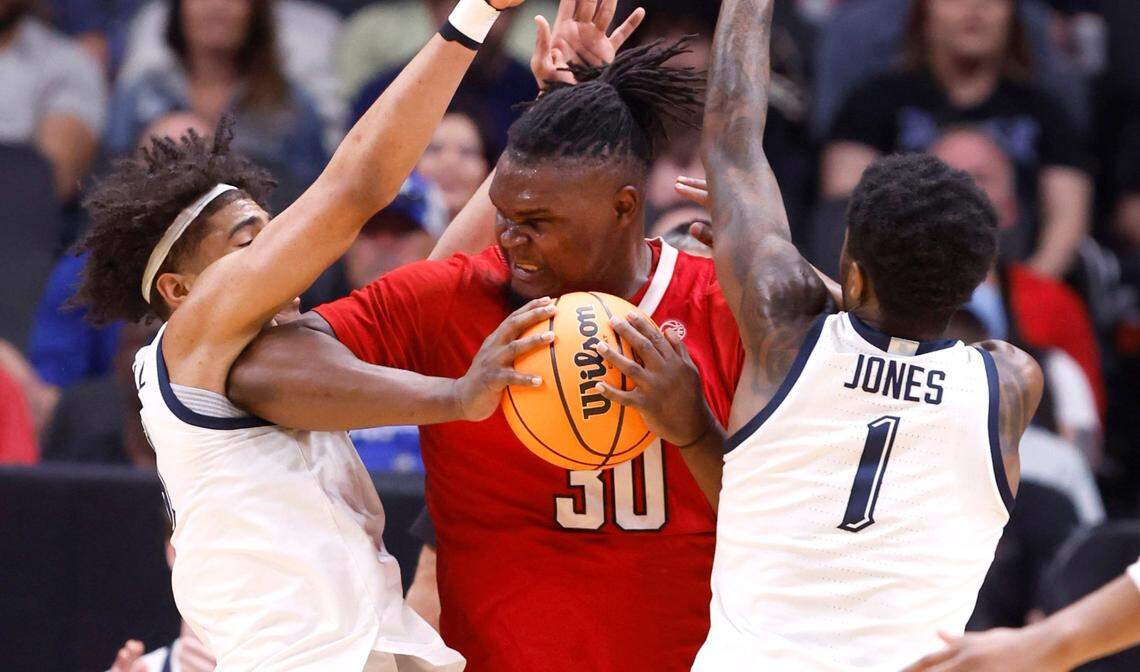 On review, Marquette’s Stevie Mitchell (4) is called for a foul on N.C. State’s DJ Burns Jr. (30) as Marquette’s Kam Jones (1) also defends during the first half of N.C. State’s game against Marquette in their NCAA Tournament Sweet 16 game at the American Airlines Center in Dallas, Texas, Friday, March 29, 2024.