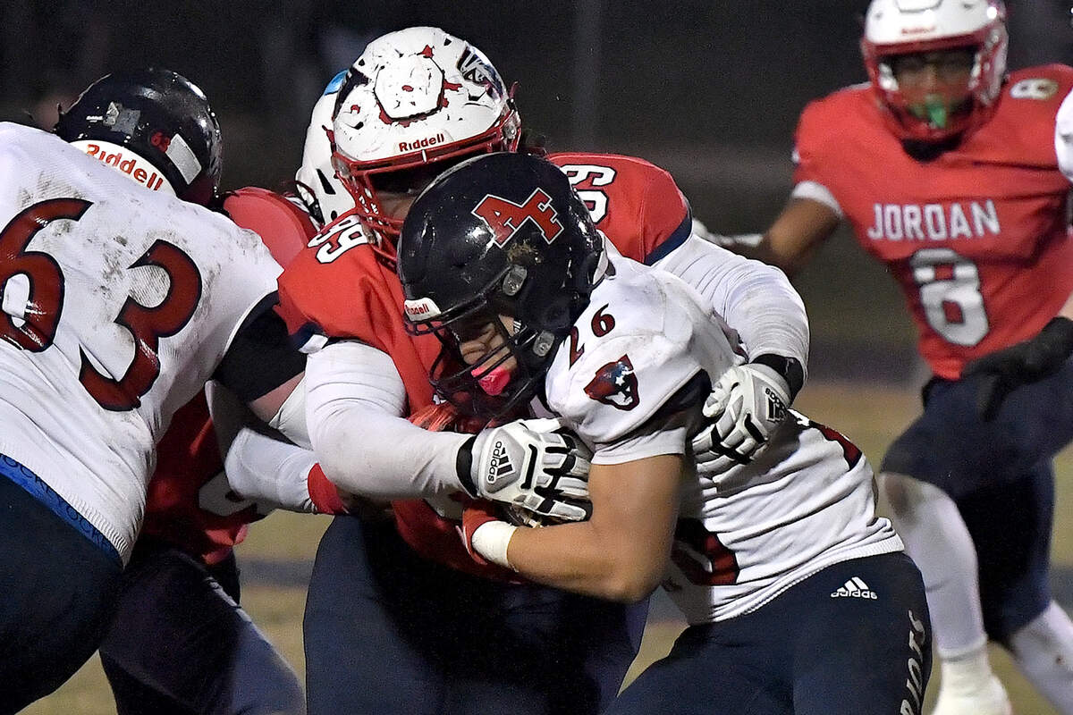 Jordan’s defensive tackle Angelo Smith (99) grapples Apex Friendship’s Jaden Avery (26) during the first half. The Apex Friendship Patriots and the Durham Jordan Falcons met in the second round of the NCHSAA 4A playoffs in Durham, N.C. on November 22, 2024.
