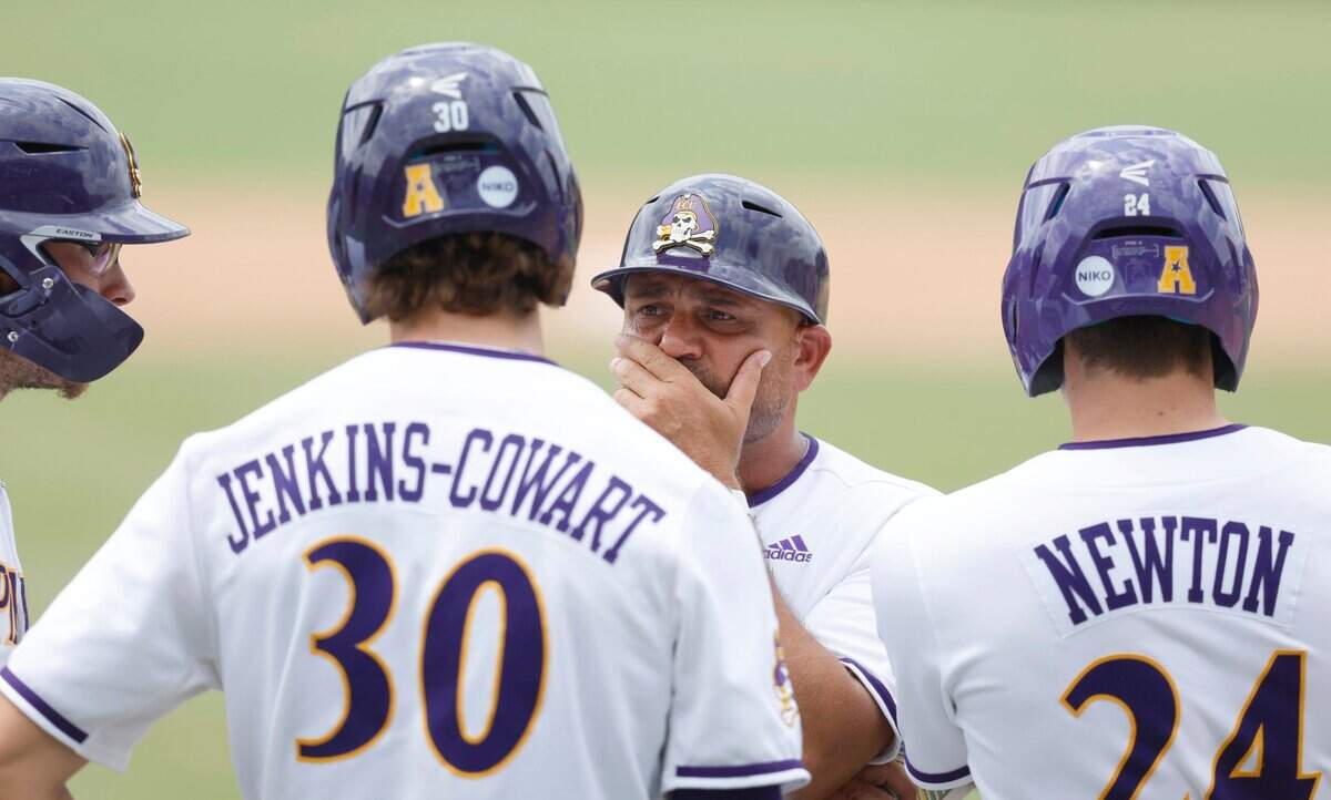East Carolina coach Cliff Godwin talks with Josh Moylan (66), Jacob Jenkins-Cowart (30) and Ben Newton (24) during ECUs 13-7 victory over Texas in the Greenville Super Regional at Clark-LeClair Stadium Friday, June 10, 2022.