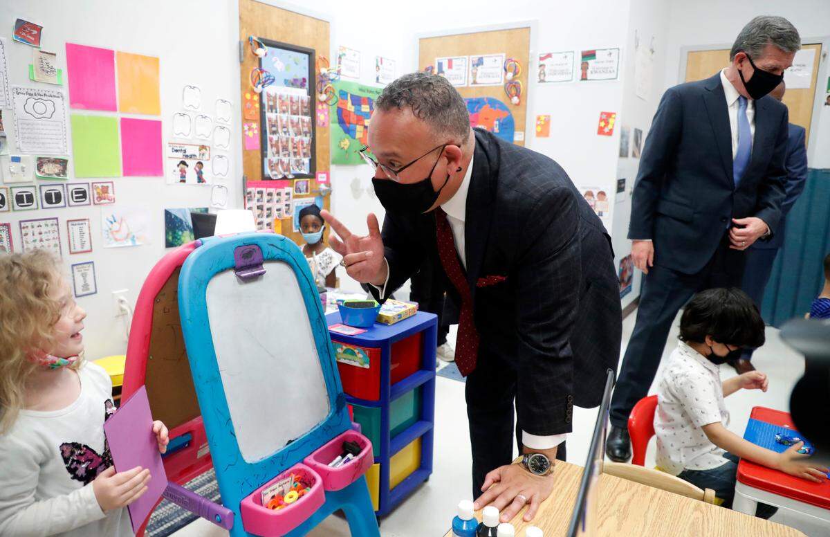 U.S. Education Secretary Miguel Cardona talks with Hannah Demille as Sec. Cardona and Gov. Roy Cooper tour Bright Beginnings Child Development Center in Cary, N.C., Thursday, May 20, 2021.