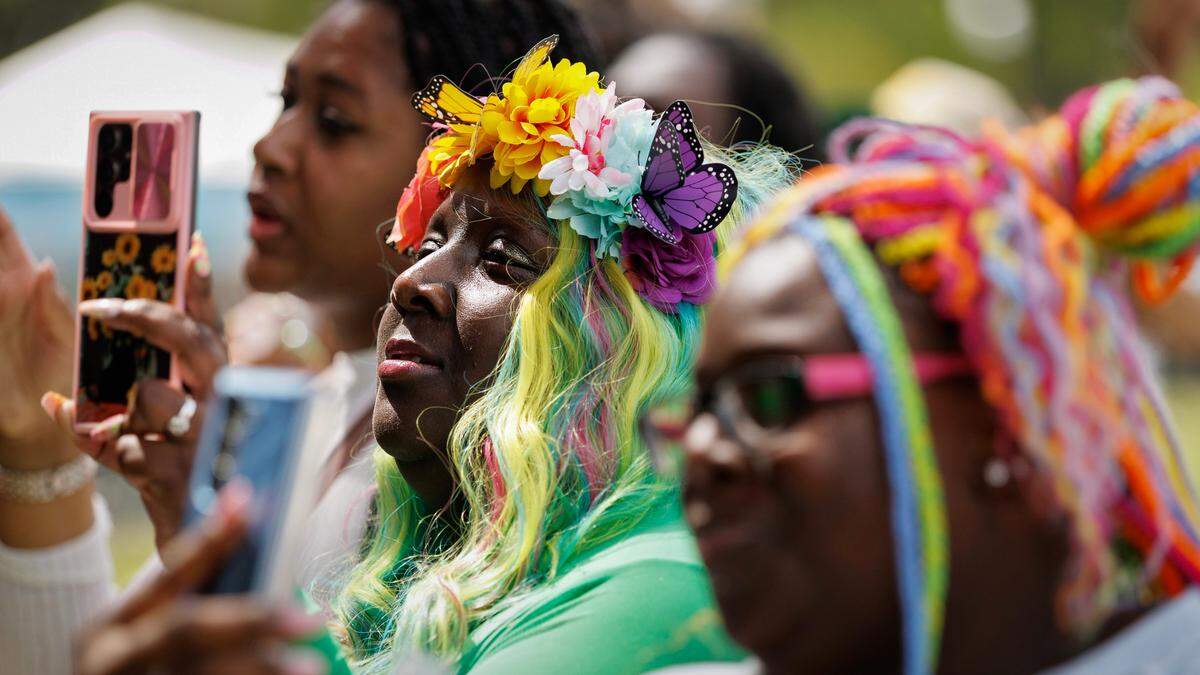 Debbie Annette Curtis, center, listens to a performance by Omen during the fifth Dreamville Festival on Saturday, April 5, 2025, at Dorothea Dix Park in Raleigh, N.C.