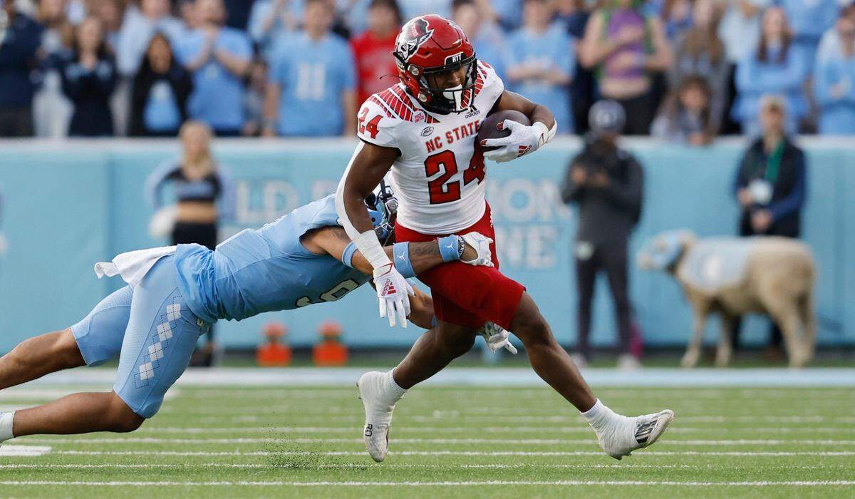 North Carolina defensive back Cam’Ron Kelly (9) tackles N.C. State running back Michael Allen (24) during the first half of N.C. State’s game against UNC at Kenan Stadium in Chapel Hill, N.C., Friday, Nov. 25, 2022.
