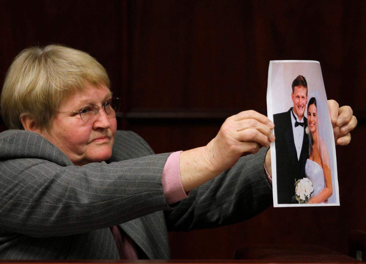 Pat Young, Jason YoungÕs mother, shows a wedding portrait of his son and Michelle Young to the jurors as she testifies for her son Monday. Young is accused of killing his pregnant wife in 2006.