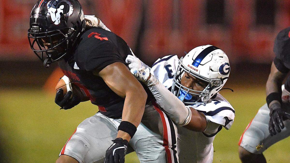 Rolesville running back Amir Brown (2) runs for yardage against Grimsley’s Kosci Barnes (3) during the first half. The Rolesville Rams and the Greensboro Grimsley Whirlies met in a non-conference football game in Rolesville, N.C. on August 30, 2024.