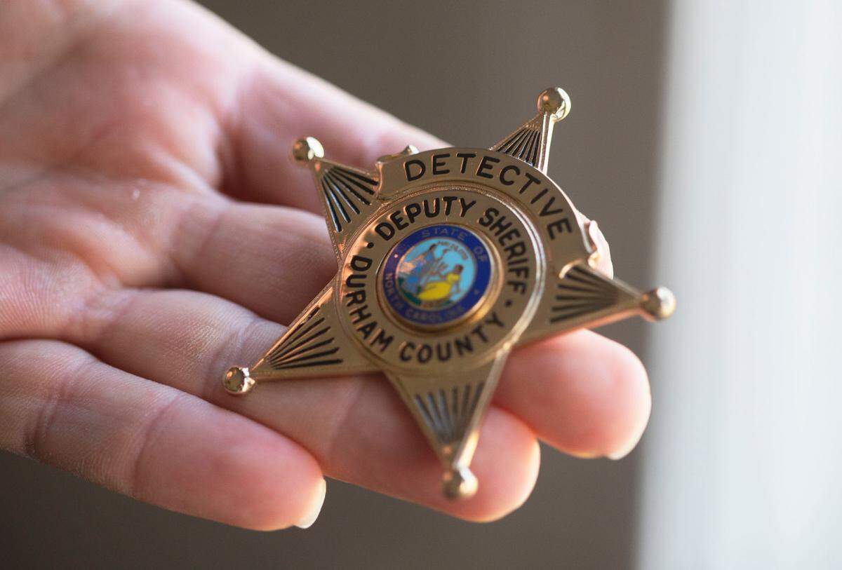 William Carson holds a Durham County sheriff’s badge he ordered before resigning in Durham, N.C. on Thursday, Jan. 27, 2022.