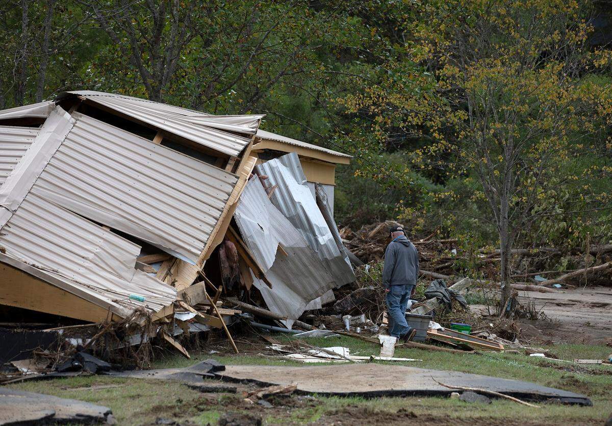 A person walks next to a demolished building in Frank, N.C. on Tuesday, Oct. 1, 2024, days after Hurricane Helene brought heavy rain and flooding to the western part of the state.