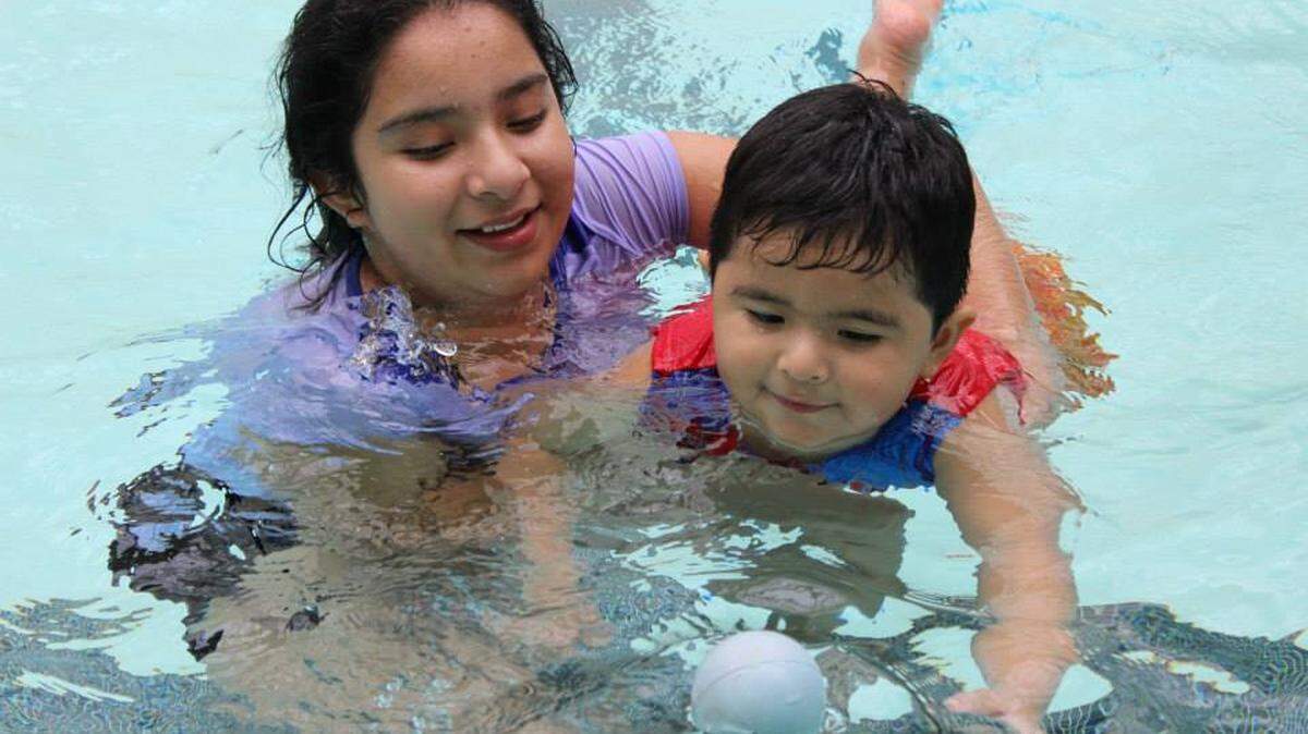 A student volunteer guides a child through swimming techniques at Bowman Gray Memorial Pool in 2014. According to the CDC, drowning is the leading cause of death for children in the U.S. 
