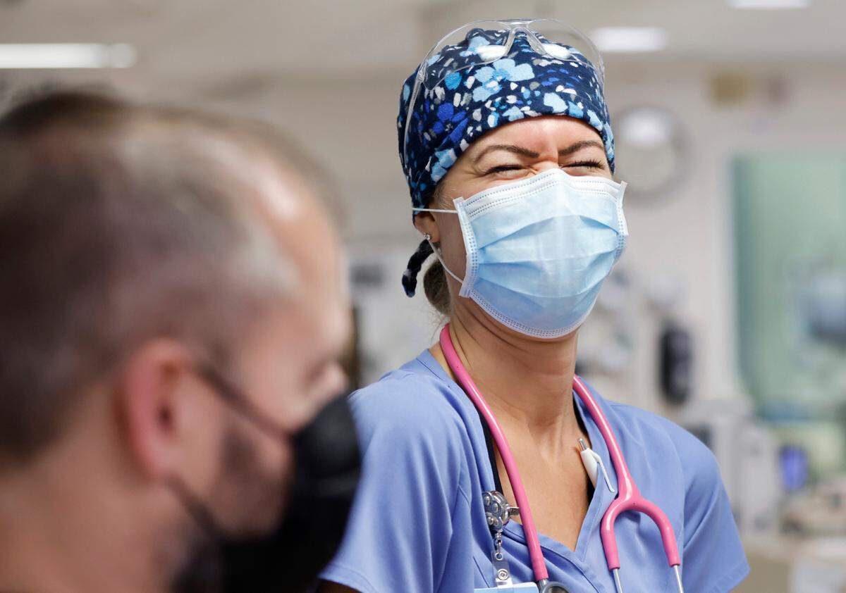 Erica South, a nurse in the emergency department, laughs while talking with nurse manager Danny Yoder, left, during her shift at UNC REX Hospital in Raleigh, N.C., Friday, October 1, 2021.